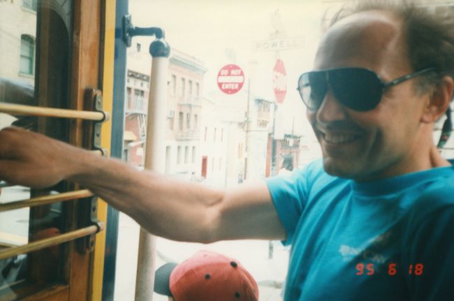Papa and Peter hanging onto cable car in San Francisco
