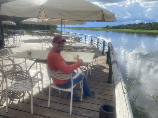 2/5/23 Ray relaxing with a drink on the Okivango at Rundu
