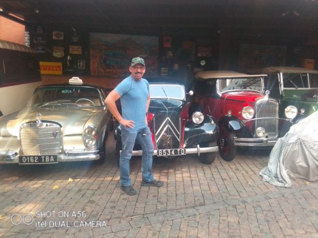 12/9/23 Ray in front of Antique Cars at cafe in Antananarivo with nice waitstaff
