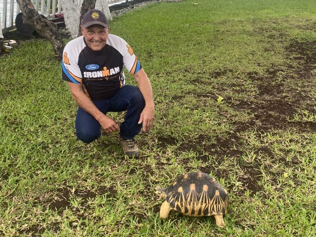 Paul playing with large land turtle on lawn behind our hotel in Comoros
