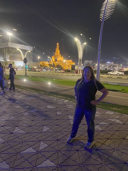 Helen in Doha at night walking along shore of Persian Gulf
