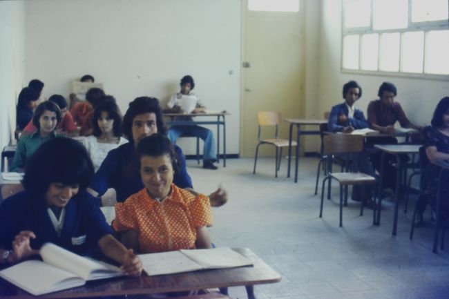 A classroom scene of a class being taught by Paul or Helen
